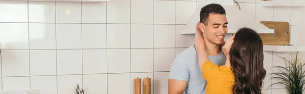 Orientation panoramique de fille étreignant petit ami bi-racial dans la cuisine — Photo de stock