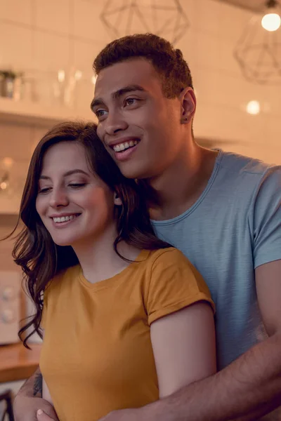 Glückliches multiethnisches Paar, das zu Hause lächelt — Stockfoto