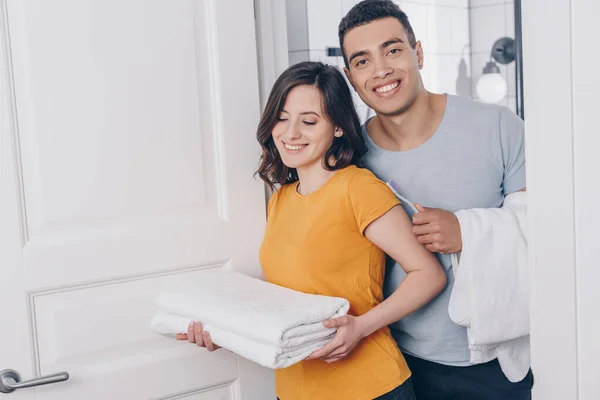 Positive multirassische Paar hält Handtücher im Badezimmer — Stockfoto