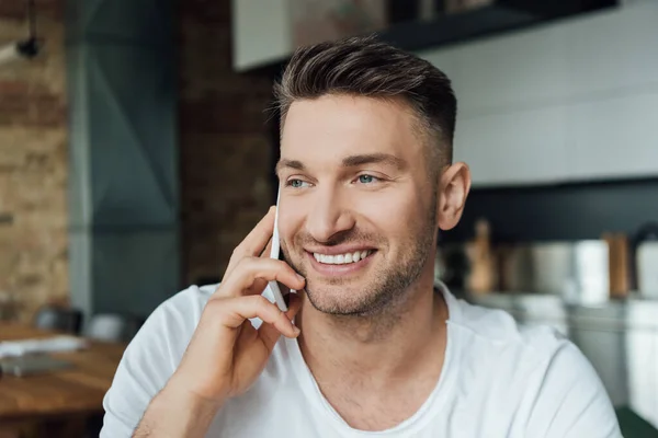 Lächelnder Mann spricht im Wohnzimmer auf Smartphone — Stockfoto