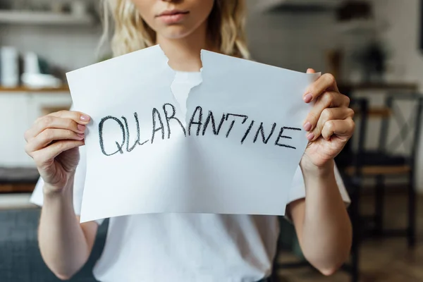 Cropped view of young woman tearing card with quarantine lettering at home — Stock Photo