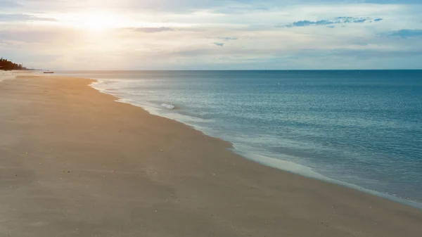 Rustige blauwe zee op het strand met sunrise. — Stockfoto