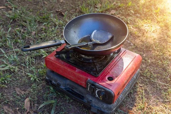 Portable gas stove and a frying pan in the camp.