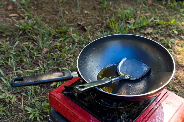 Portable gas stove and a frying pan in the camp.