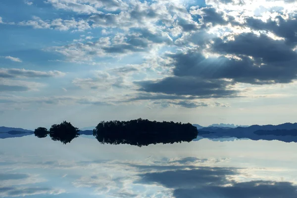 Paesaggio nuvoloso con luce solare sul lago . — Foto Stock