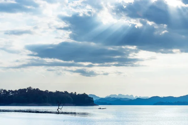 Paesaggio nuvoloso con luce solare sul lago . — Foto Stock