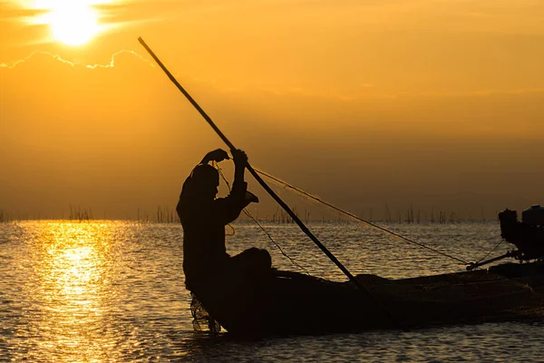 Silhouette pêcheur et coucher de soleil ciel sur le lac . — Photo