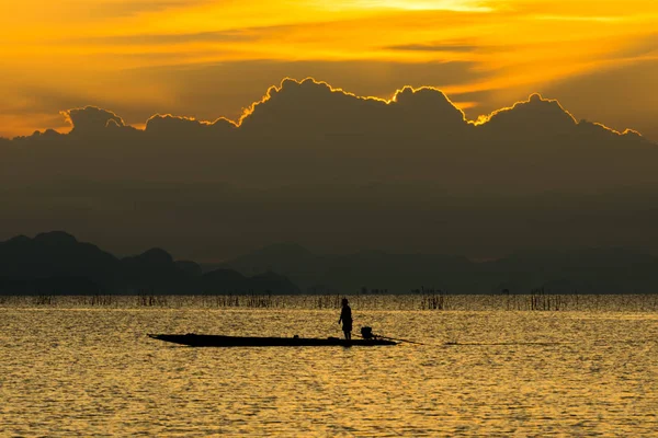 Silueta pescador y puesta del sol cielo en el lago . — Foto de Stock