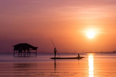 Balıkçılar ve balıkçı tekneleri gölde yüzmek.