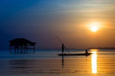 Balıkçılar ve balıkçı tekneleri gölde yüzmek.