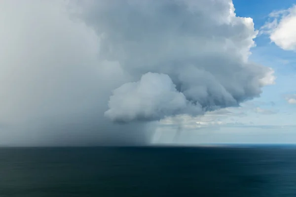 Nuages et pluie tombent dans la mer . — Photo