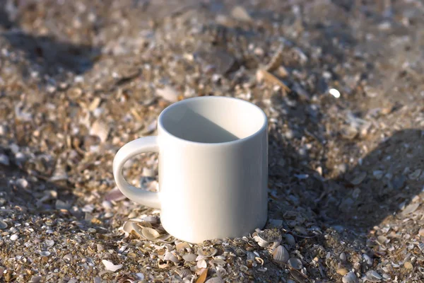 Beyaz kupa kum üzerine kahve. — Stok fotoğraf