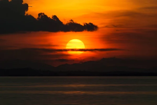Západ slunce u jezera s temný mrak. — Stock fotografie
