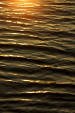 Karanlık su yüzeyi güneş ışığı ile.