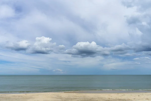 ไม่มีใครบนชายหาดที่มีท้องฟ้าสีฟ้าและเมฆในฤดูฝน . — ภาพถ่ายสต็อก