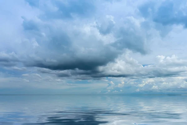 Mirror of the sea with blue sky and clouds in rain season. Royalty Free Stock Photos