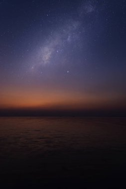 Gökyüzü yıldızlı gölde alacakaranlıkta gün batımında.