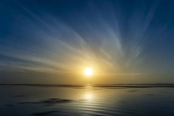 Nascer do sol acima do lago com linha de nuvem e movimento na água — Fotografia de Stock