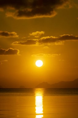 Göl kenarında gün batımı kara bulutlarla.