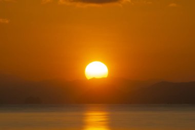 Göl kenarında gün batımı kara bulutlarla.