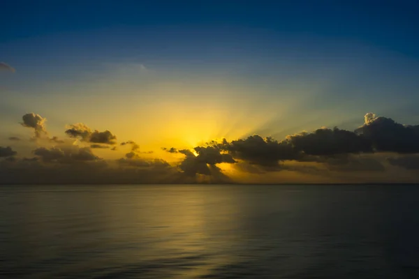 Céu do pôr do sol no lago com nuvens escuras e raios de sol . — Fotografia de Stock