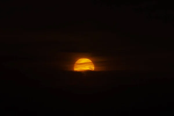 Big sun on dark sunset sky with dark clouds. — Stock Photo, Image