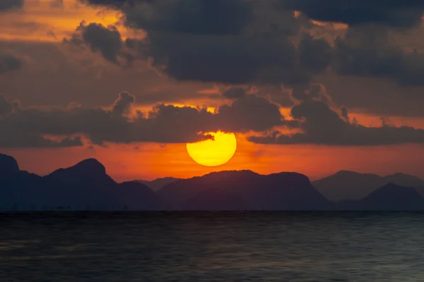 Большое Солнце Закатном Небе Над Озером Силуэтом Горы Облаками — стоковое фото