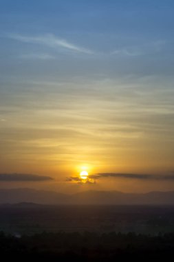 Gün batımı gökyüzü dağın tepesinde bulutlarla.