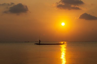 Gölde, alacakaranlık gökyüzü olan minimum siluet balıkçıları..