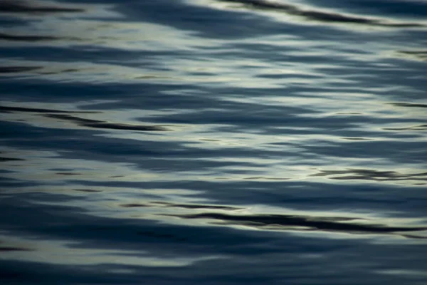 水の表面の画像に焦点を当て 湖で青い時間に柔らかい波を反映します — ストック写真
