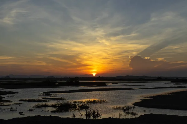 夕阳西下 湿地上空轻柔的云彩 地面上有轮廓 — 图库照片