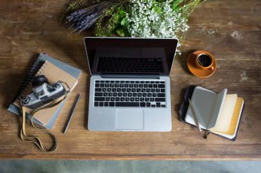 ahşap masa üzerinde laptop, Günlükler, vintage fotoğraf makinesi ve kahve Üstten Görünüm