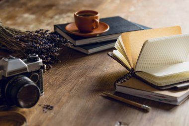 vintage photo camera, and diaries and cup of coffee on wooden tabletop clipart