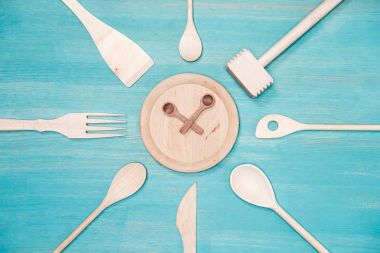 top view of various wooden kitchen utensils with clock symbol on plate clipart