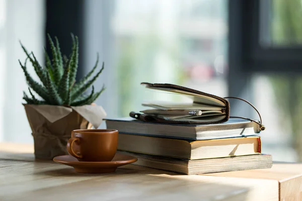 Vista de perto de livros, caderno com lápis e xícara de café em mesa de madeira — Fotografia de Stock