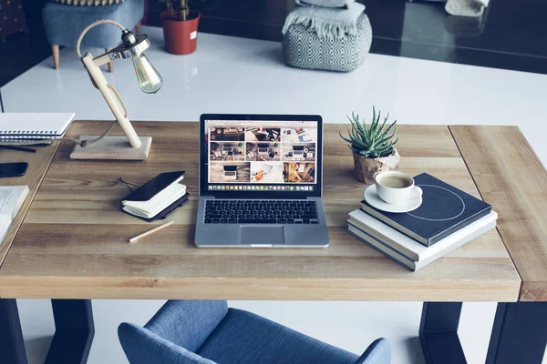 Portátil abierto, libros y una taza de café en el lugar de trabajo moderno — Foto de Stock