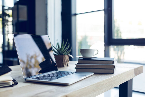Дизайн рабочего места с ноутбуком и чашкой кофе в домашнем офисе
