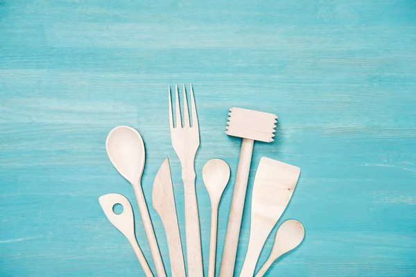 Vista superior de vários utensílios de cozinha de madeira em mesa azul — Fotografia de Stock