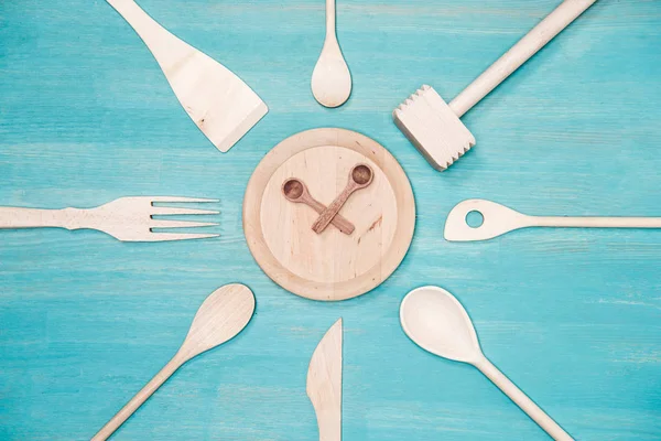 Top view of various wooden kitchen utensils with clock symbol on plate — Stock Photo, Image