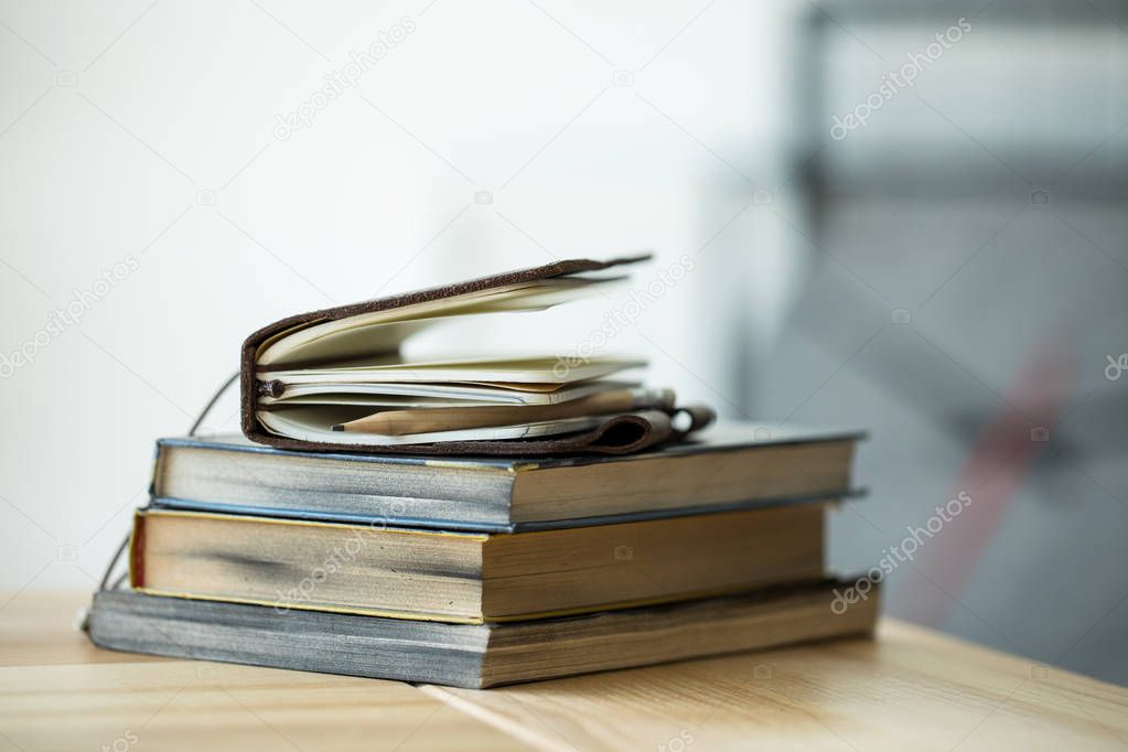 Close-up view of books and notebook with pencil on wooden table 