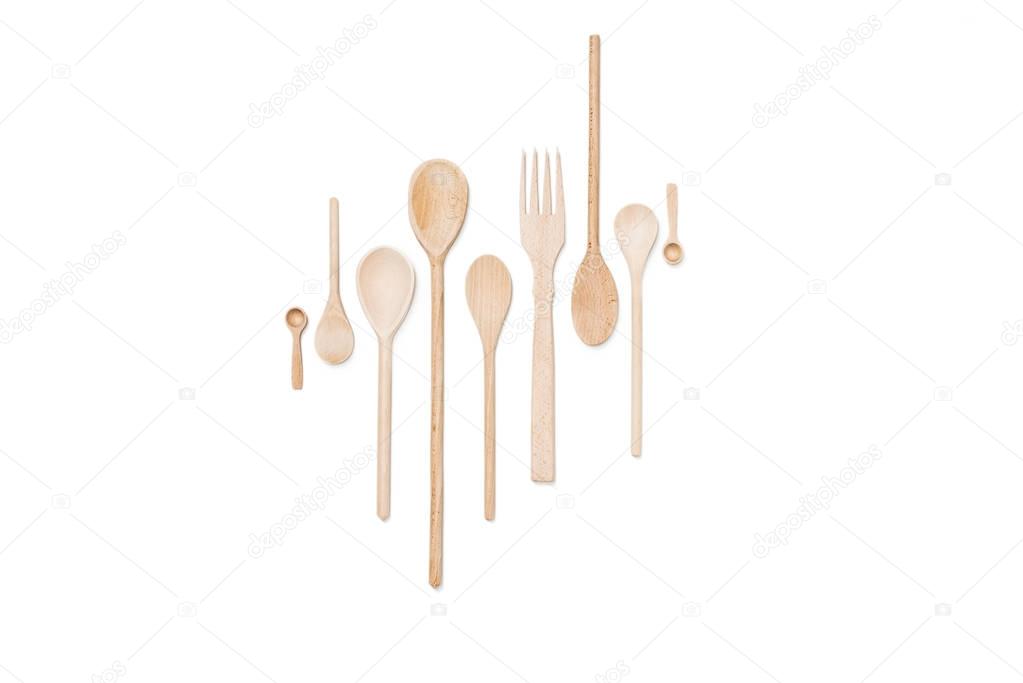 Close-up view of set of various wooden cooking utensils isolated on white