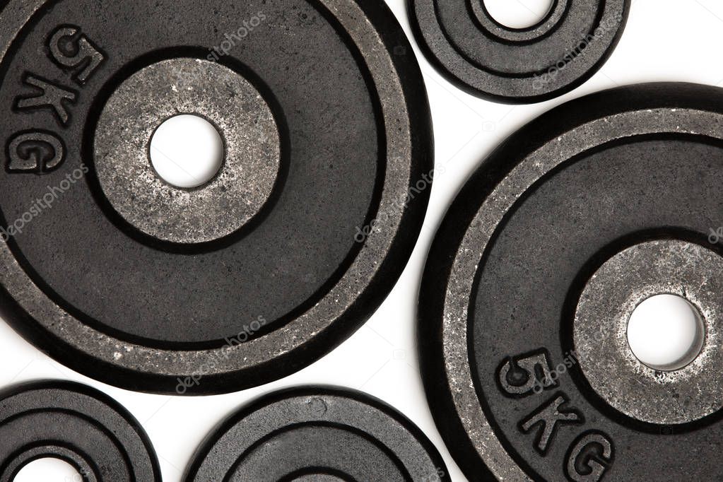 Close-up view of different weight plates for weight training isolated on white