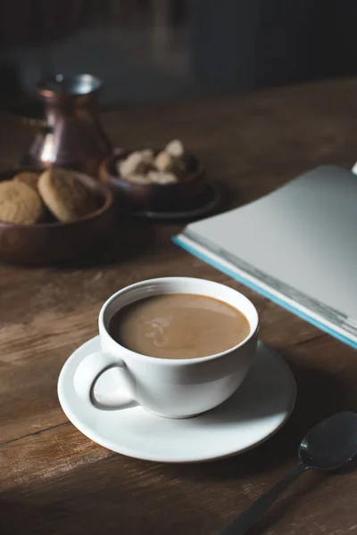 Kaffeetasse mit leerem Buch auf Tischplatte — Stockfoto