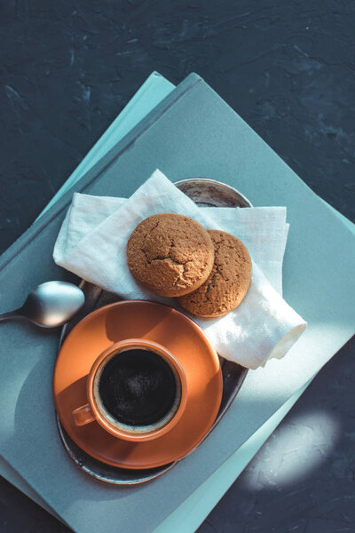 coffee with cookies on napkin and books