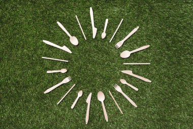 wooden spoons with forks and knives on grass clipart