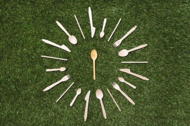 wooden spoons with forks and knives on grass clipart