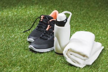 trainers with bottle of water and towel on pitch clipart