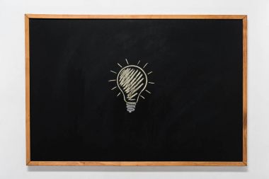 electric bulb drawn on black chalkboard