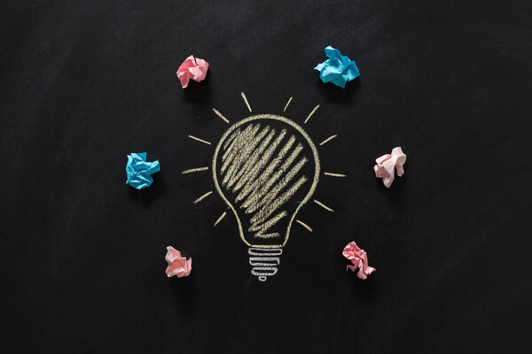 бумажный мусор с электрической лампочкой на доске
