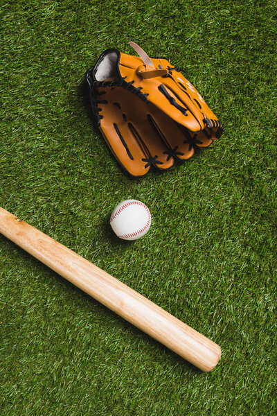baseball bat with ball and glove on grass